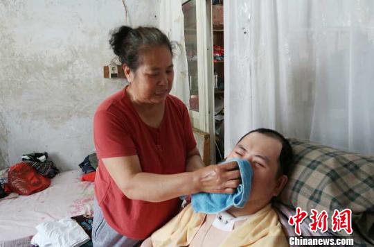 每次喂完食物后，梁青蘭都要仔細地幫兒子清理干凈。　尚明俠 攝