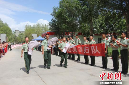部隊官兵們迎接出院歸來的李運飛(中)和其他消防戰(zhàn)士?！⊥粲?攝