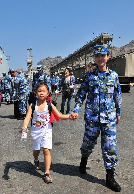 2015年3月，也門，海軍女戰(zhàn)士牽著一名小女孩的手準備登上軍艦。