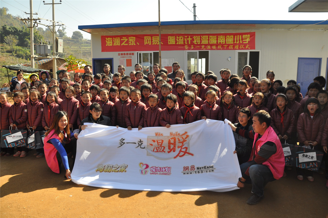 2014年11月20日，“多一克溫暖”公益團(tuán)隊來到8.3大地震的重災(zāi)區(qū)——云南省昭通市魯?shù)榭h的南筐小學(xué)。越過崎嶇山路，將一批又一批暖心羽絨服送到了師生們的手中，也將社會的關(guān)懷和愛意傳遞給了這些可愛的人。